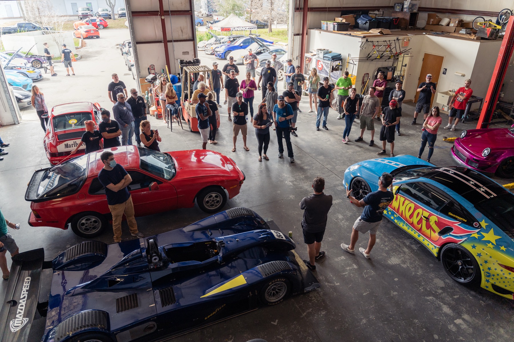 Full-service bays at Speed Syndicate filled with race cars and formula cars for race prep and performance work